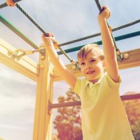happy-little-boy-climbing-on-children-playground-PK7GUUB.jpg